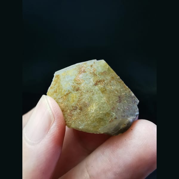 Calcite crystal with pyrite and hematite at the base — alternate view