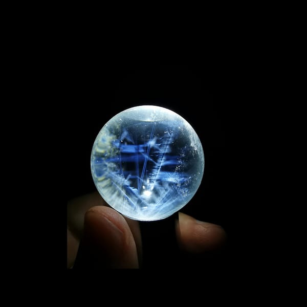 Clear quartz sphere full of feathery blue needles — complete view