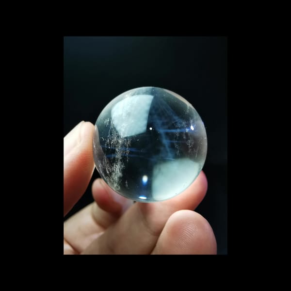Clear quartz sphere full of feathery blue needles — detail view