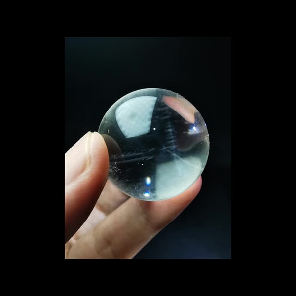 Clear quartz sphere full of feathery blue needles — detail view