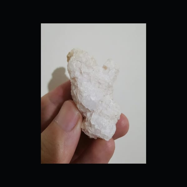 Pale pink calcite floater cluster, natural-light front view