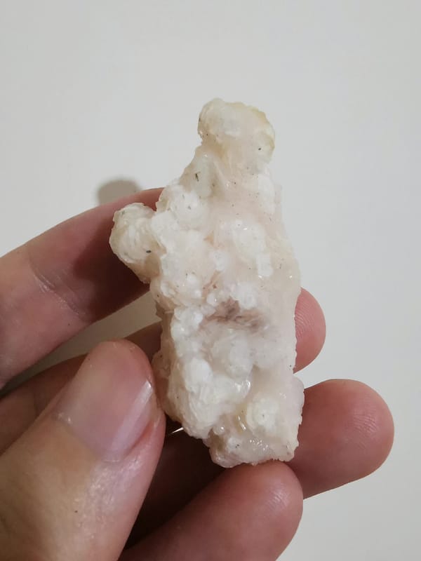 Pale pink calcite floater cluster, side view