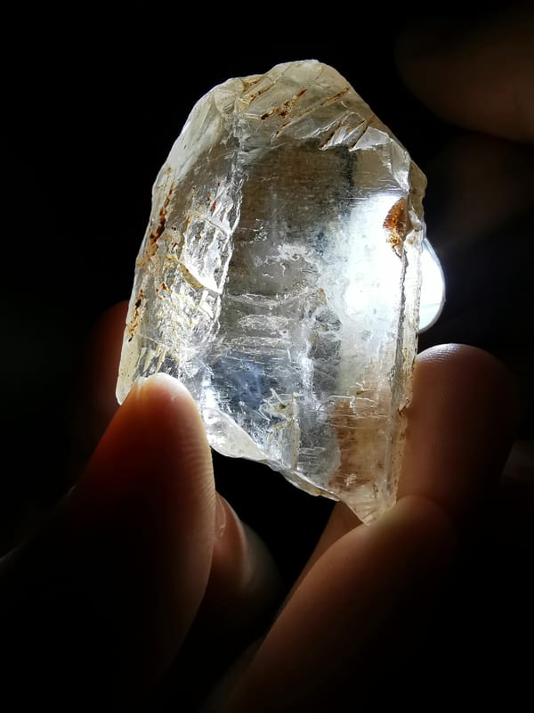 Complete side view showing the exact quartz point and needle-like inclusions under light