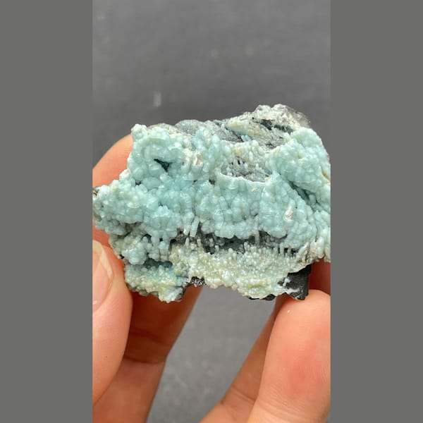 Botryoidal blue-green gibbsite crust on dark matrix from Yunnan — alternate view