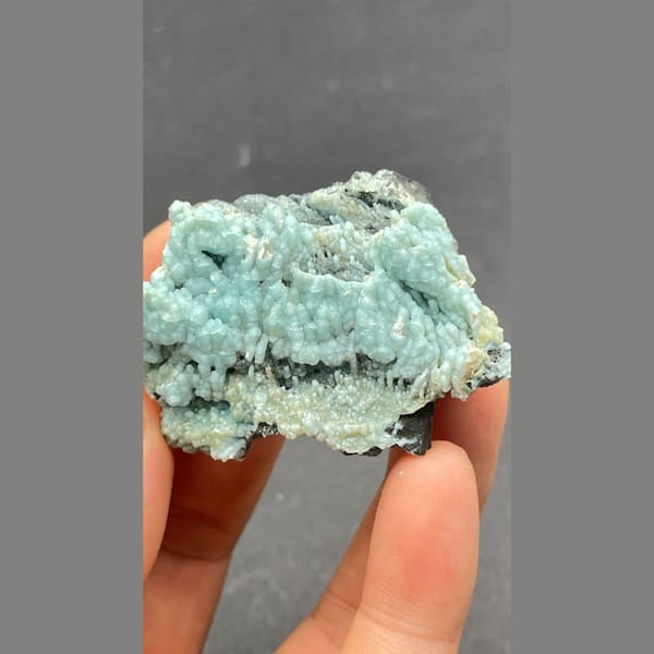 Botryoidal blue-green gibbsite crust on dark matrix from Yunnan — alternate view