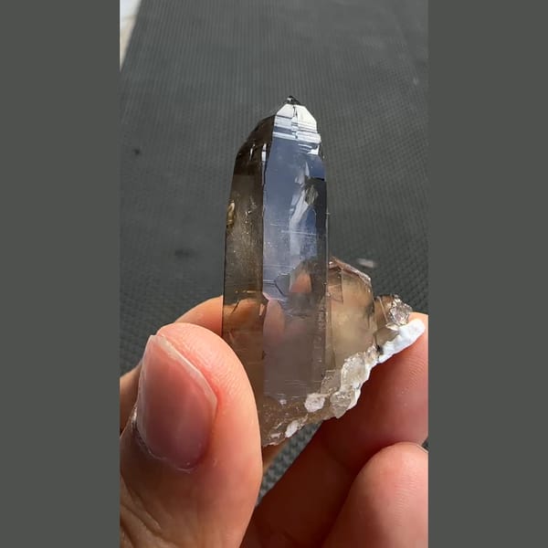 Tall smoky quartz point with smaller crystals from Yunxiao, Fujian — detail view
