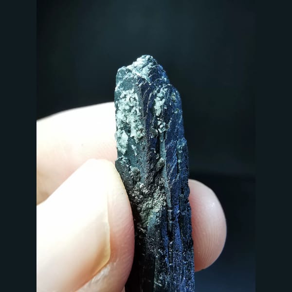 Etched black ilvaite crystal with tiny quartz — detail view