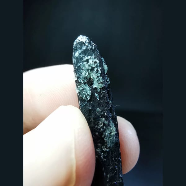 Etched black ilvaite crystal with tiny quartz — detail view