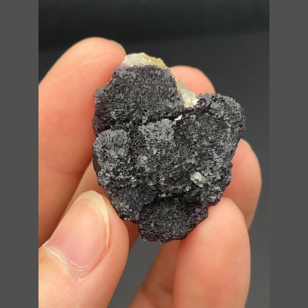 Dark purple fluorite with layered stepped growth from Henan — detail view