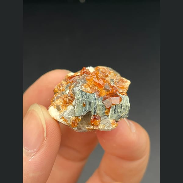 Orange spessartine garnet with smoky quartz and mica from Fujian — detail view