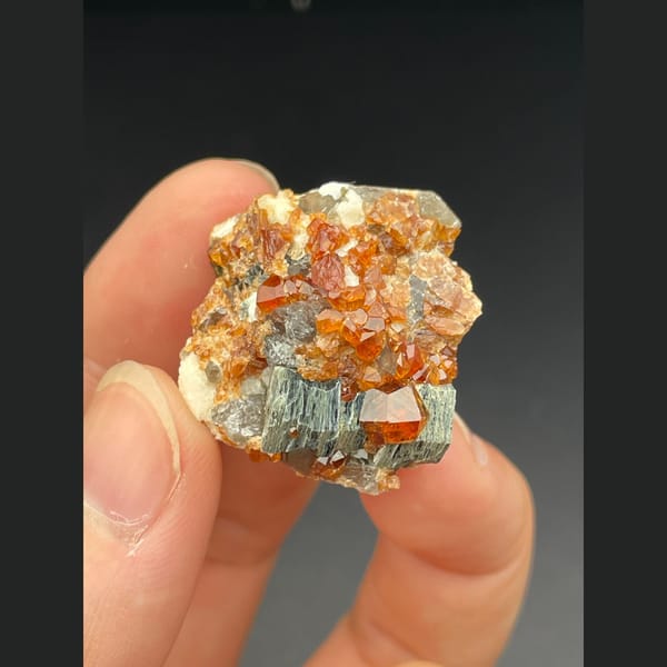 Orange spessartine garnet with smoky quartz and mica from Fujian — detail view