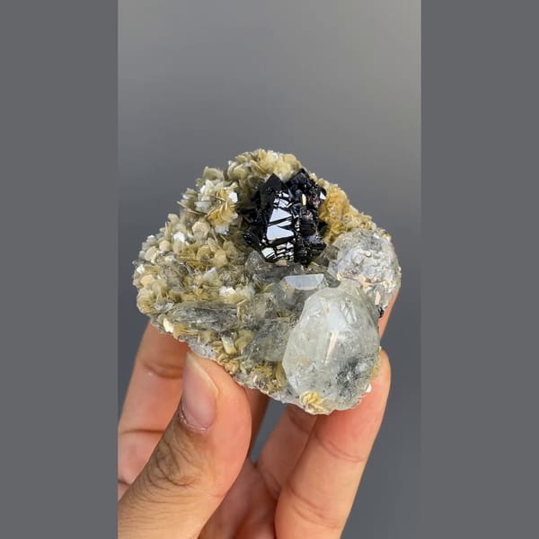 Black cassiterite with pale aquamarine on mica from Xuebaoding, Sichuan — complete view