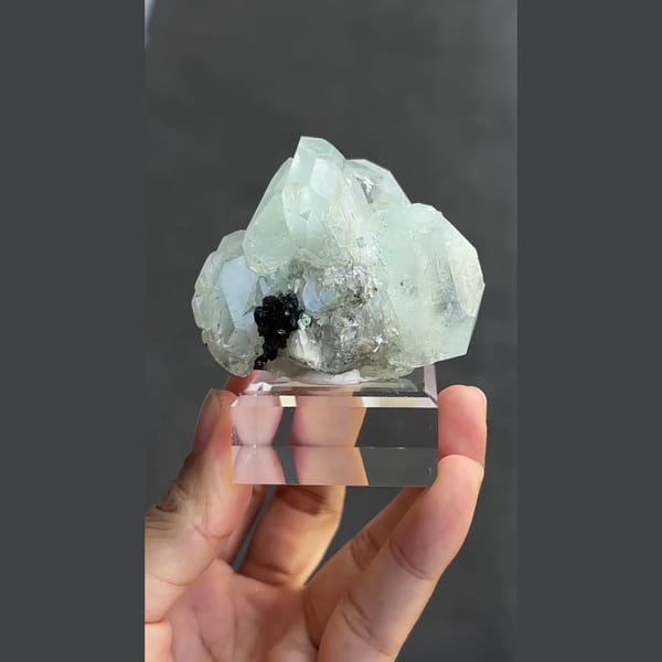 Pale green-blue aquamarine with black cassiterite from Xuebaoding, Sichuan — detail view