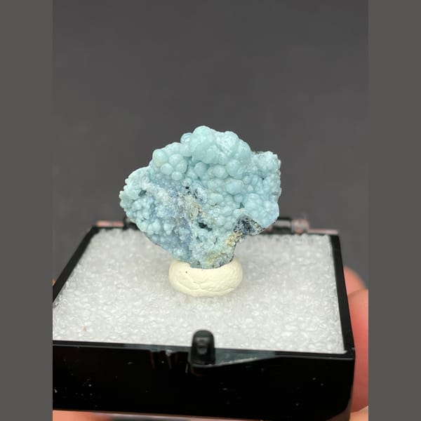 Cluster of frosted pale blue gibbsite spheres from Yunnan — complete view