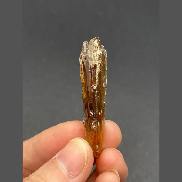 Slender glossy amber calcite crystal from Guizhou — detail view