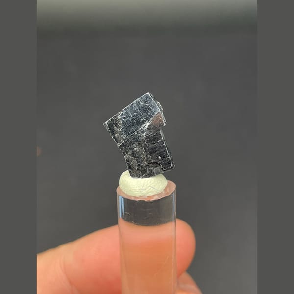 Small bright silver-grey cubic galena crystal — complete view