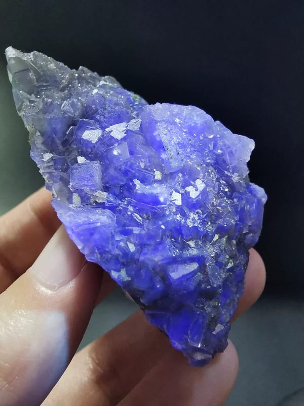 Gray-green fluorite cluster under blue-violet alternate illumination