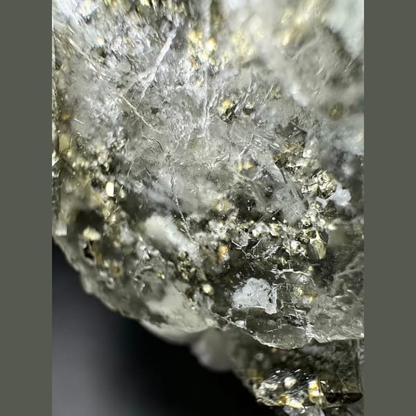 Clear glassy fluorite with golden pyrite cubes — detail view