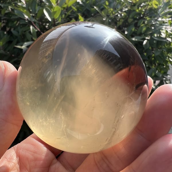 Citrine sphere glowing amber at its right edge with white wisps inside
