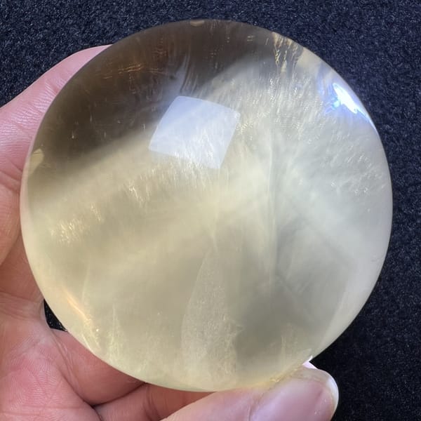 Close view of white Rutilated streaks crossing the citrine sphere