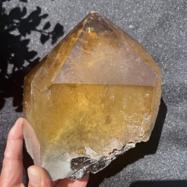 Side view of the citrine point with a rough grey lower edge