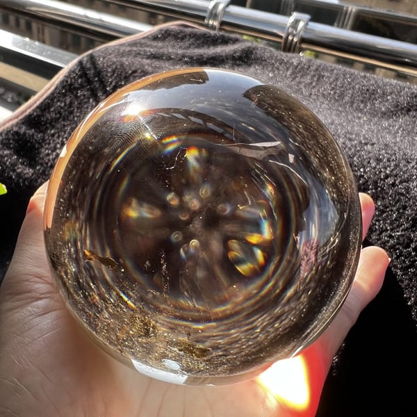 Citrine sphere showing a radial pattern of inner reflections and specks