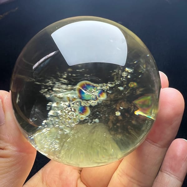Rainbow bubbles and glittering inclusions across the citrine sphere