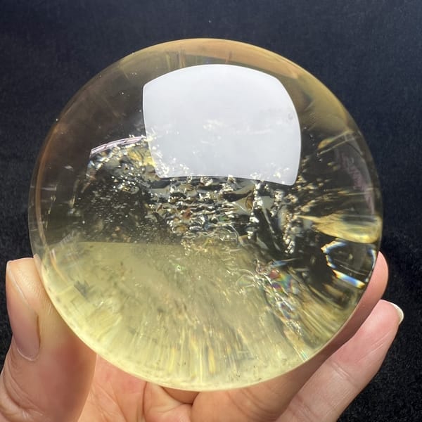 Pale golden citrine with a sparkling inclusion layer and yellow glow below