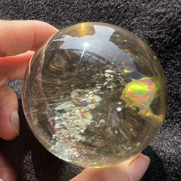 Citrine sphere with a large rainbow patch on the right side