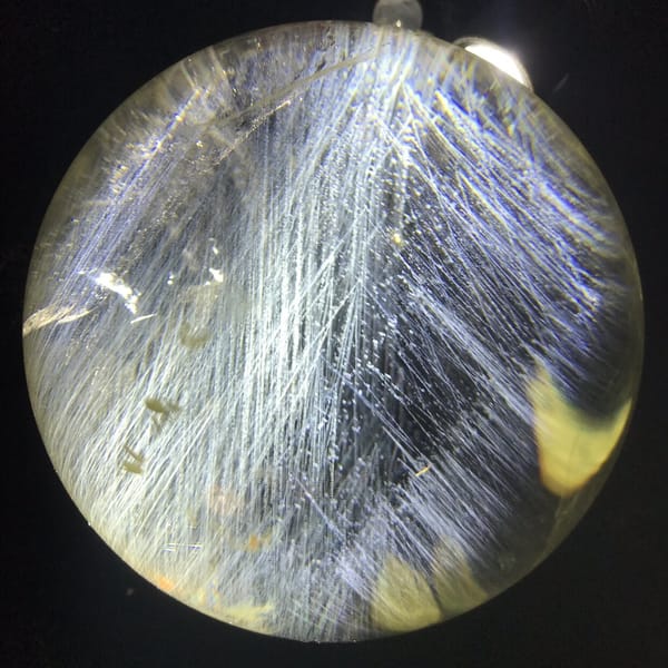 Blue needle field with a yellow glow at the lower right of the sphere