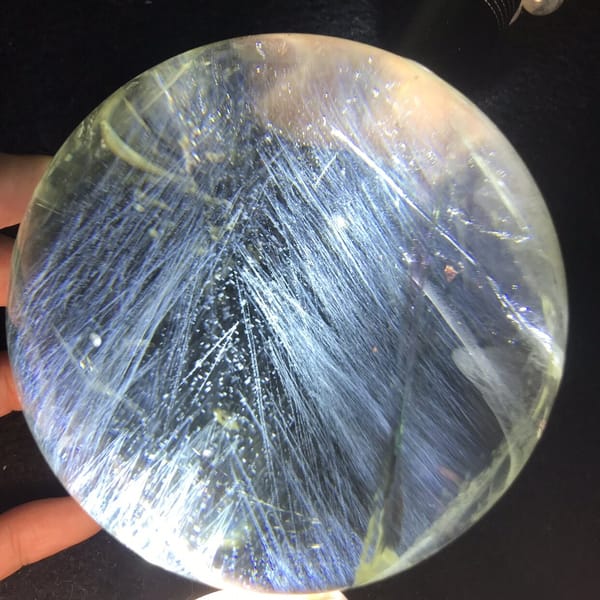 Citrine sphere with needles fanning out like feathers from the centre