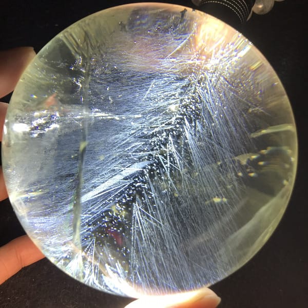 Citrine sphere with needle sprays and a clear yellow edge