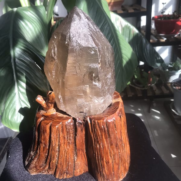 Citrine crystal on its stand showing a stepped face and small cavity