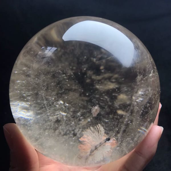 Clear side of the sphere showing a small peach starburst inclusion near the base