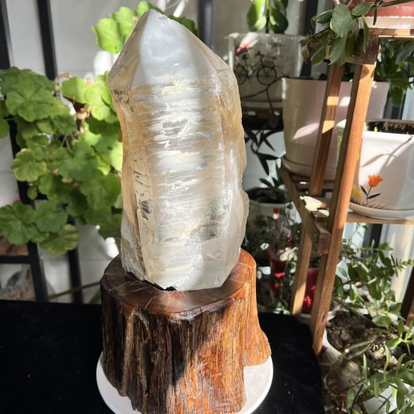 Narrow side of the crystal on stand with layered terraces down its face