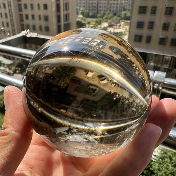 Outdoor view of the polished sphere magnifying the street scene behind