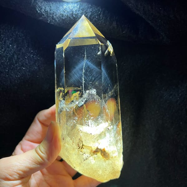 Citrine point torchlit on black, blue needle pyramid above a glowing golden base