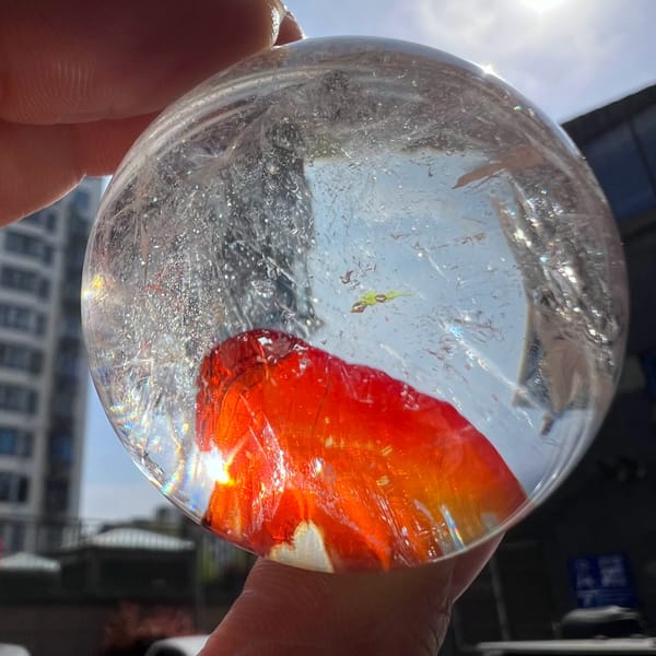 Red-orange inclusion filling the lower part of the sphere against a city backdrop