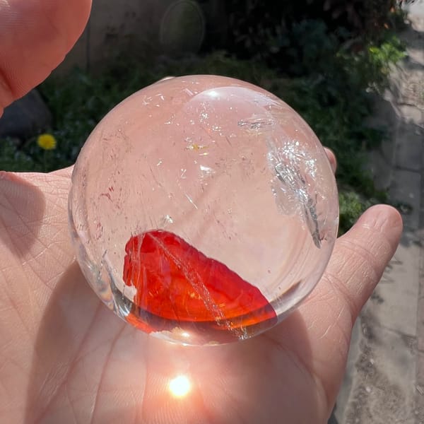 Red inclusion lit by sun shining up through the bottom of the sphere