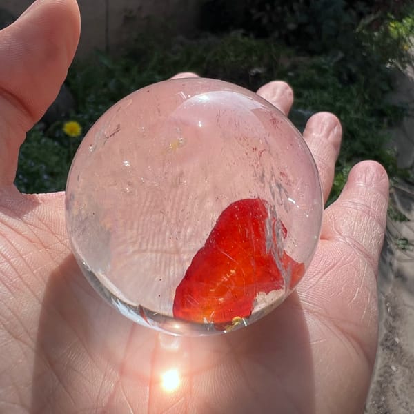 Small sphere in a palm with the red mass rising on one side
