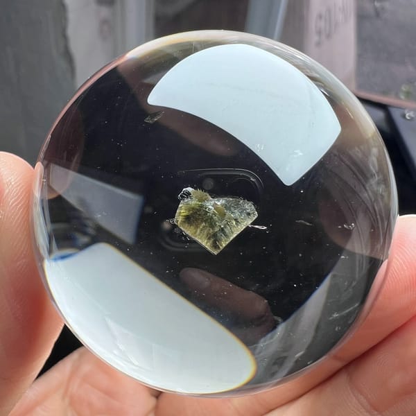 Very clear quartz sphere with a yellow-green mica heart floating at its centre