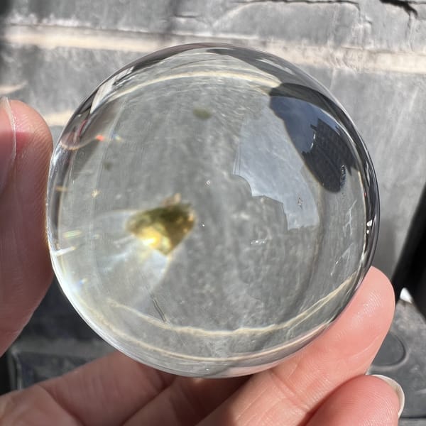 Mica flake glowing golden-green inside the transparent quartz