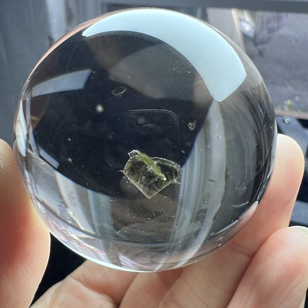 Green heart inclusion near the lower edge of the polished sphere