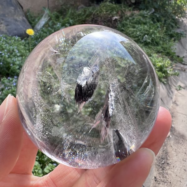 Narrow dark mica blades rising vertically through the clear sphere