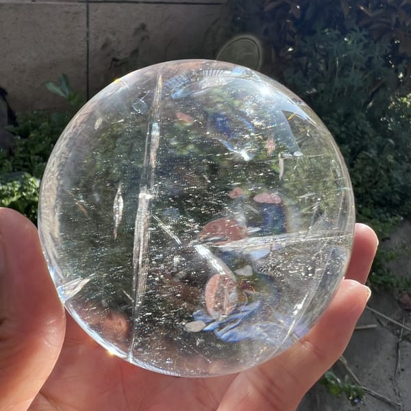 Sphere outdoors in shade showing clear quartz and faint fracture planes