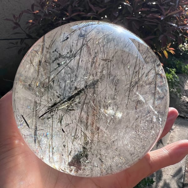 Dark mica blade crossing diagonally through the clear Madagascar sphere