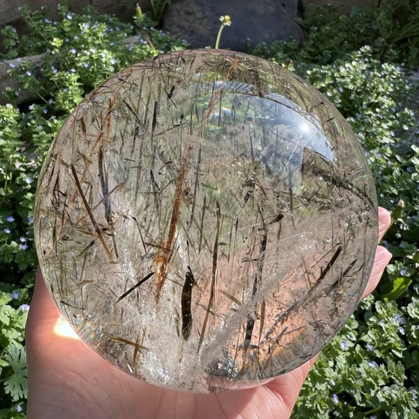 Sunlit sphere glowing warm with long amber mica blades running vertically