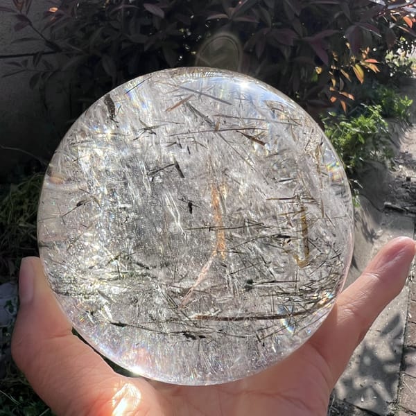 Clear quartz face showing fine scattered blades and a central amber streak