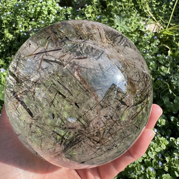Sphere held low with mica blades crisscrossing like straw in ice