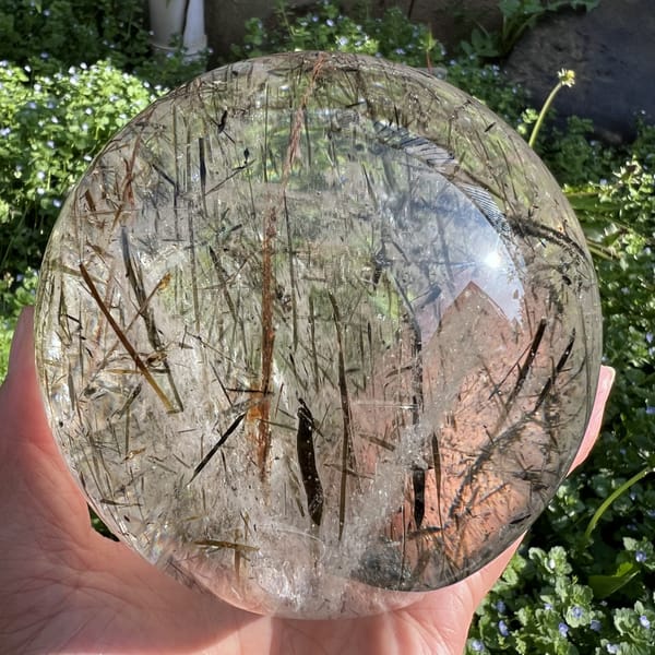 Warm-lit view of the sphere with a long amber blade down the centre
